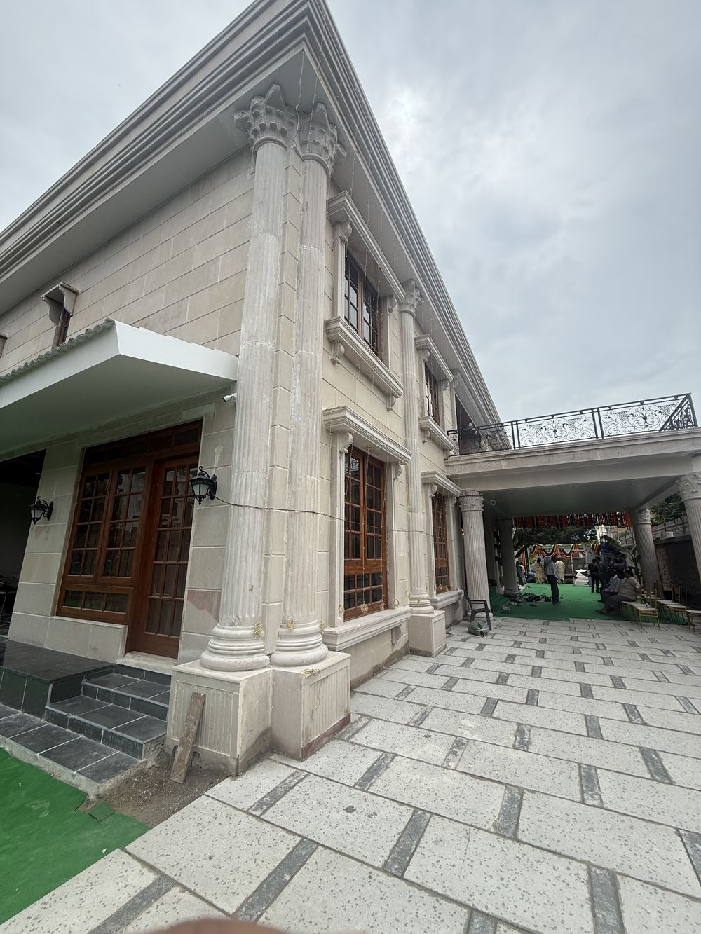 Corner of the Hyderabad residence: fluted stone columns, carved capitals and natural stone paving